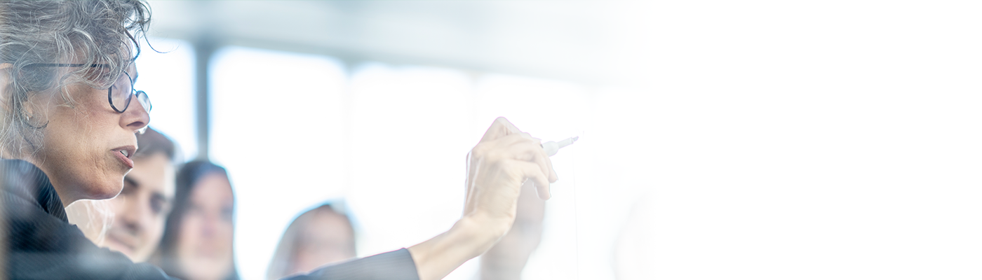 Older woman pointing marker at a whiteboard